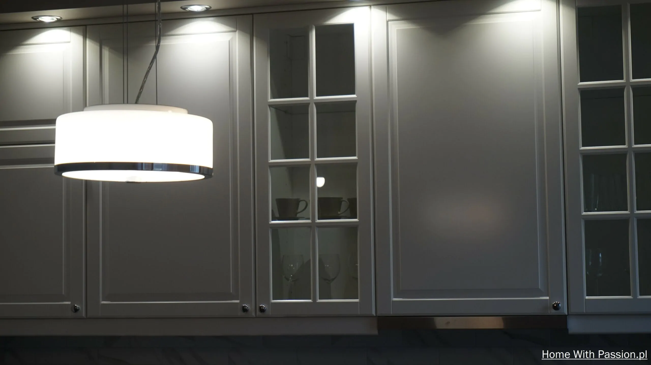 Aneks kuchenny IKEA Bodbyn w stylu Hampton – przeszklone witryny, biała zabudowa i nowoczesne oświetlenie