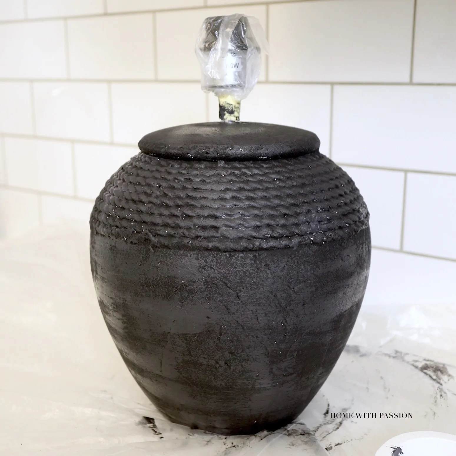 Pomalowana na czarno ceramiczna lampa stołowa w trakcie renowacji