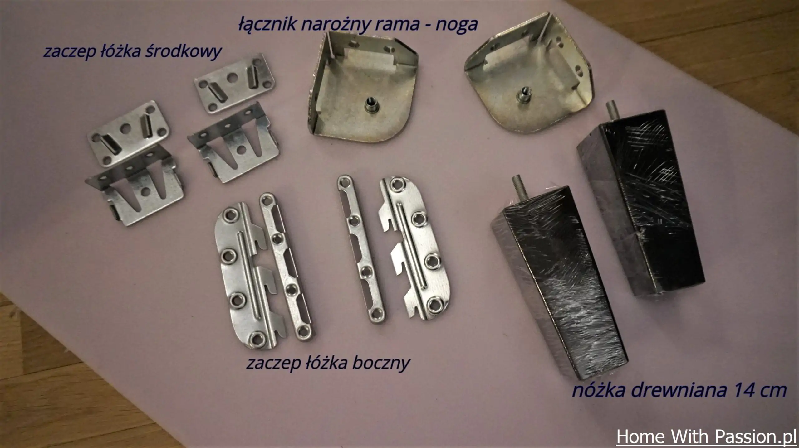 Zestaw elementów montażowych do ramy łóżka: łączniki narożne, zaczepy i nóżki drewniane.