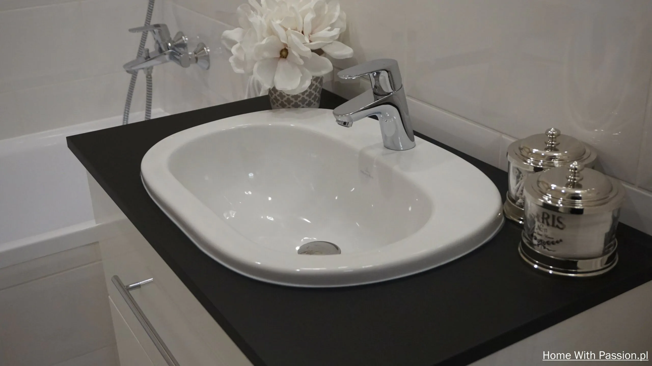 Umywalka w małej łazience Hampton z czarnym blatem, chromowaną baterią i stylowymi dodatkami