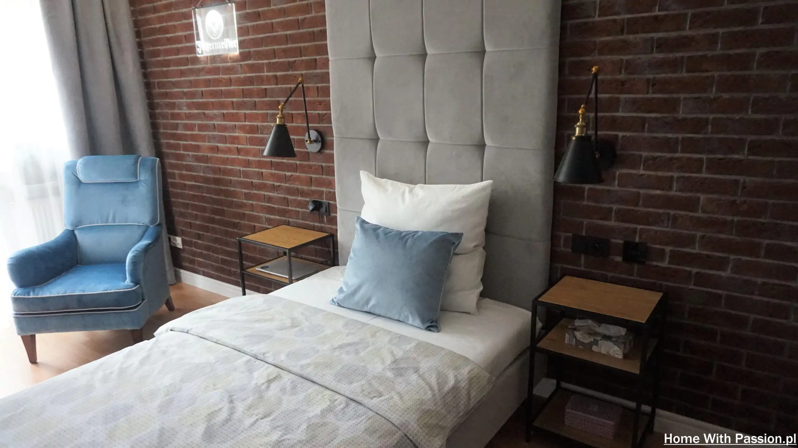 Pokój młodzieżowy loft z łóżkiem, fotelem i ceglaną ścianą
