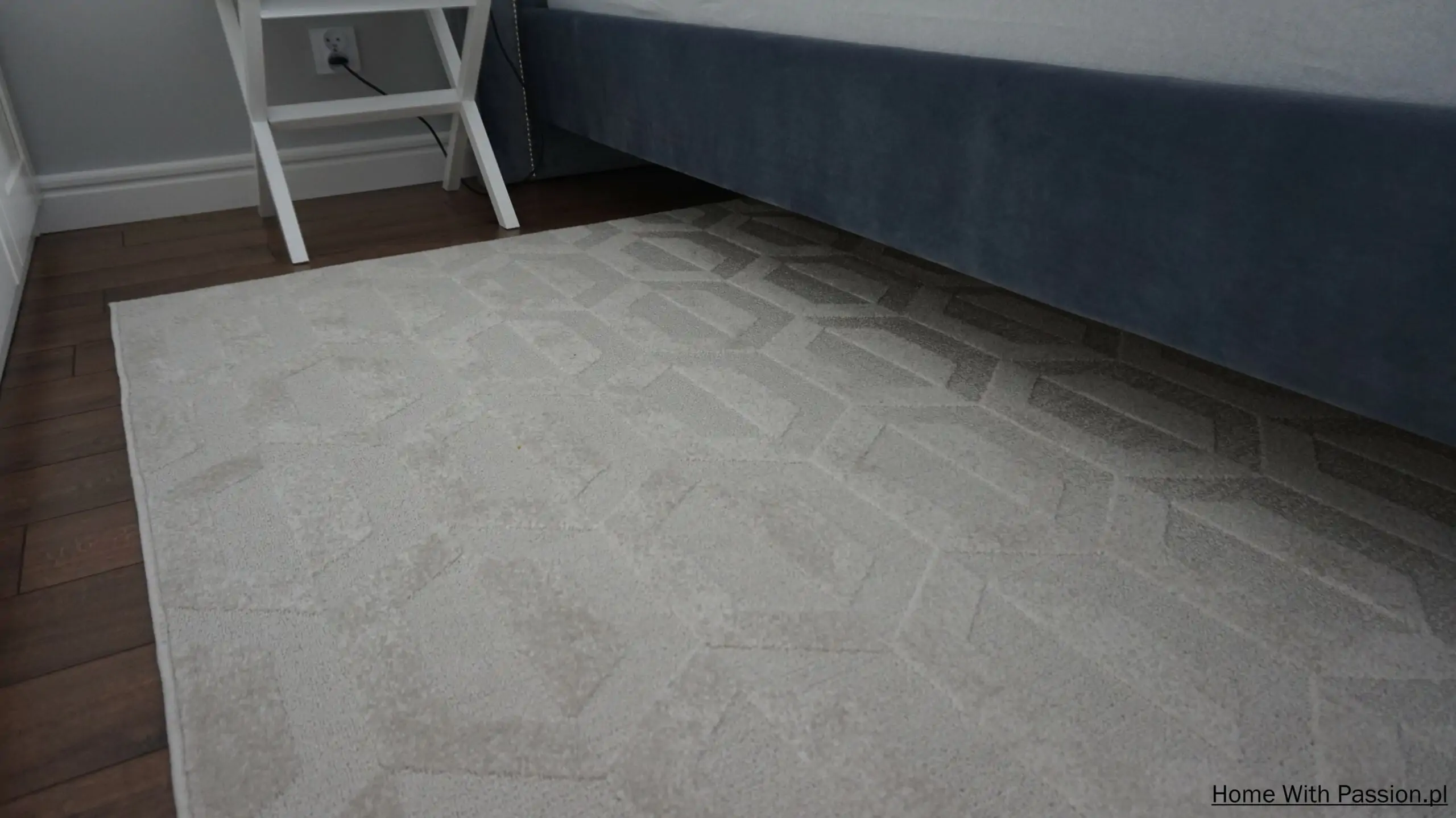 Dywan w geometryczny wzór pod łóżkiem w eleganckiej aranżacji