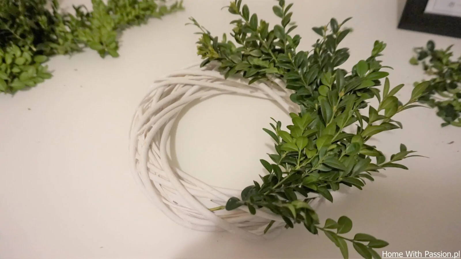 tworzenie wianka wielkanocnego DIY – mocowanie gałązek do białej wiklinowej bazy krok po kroku